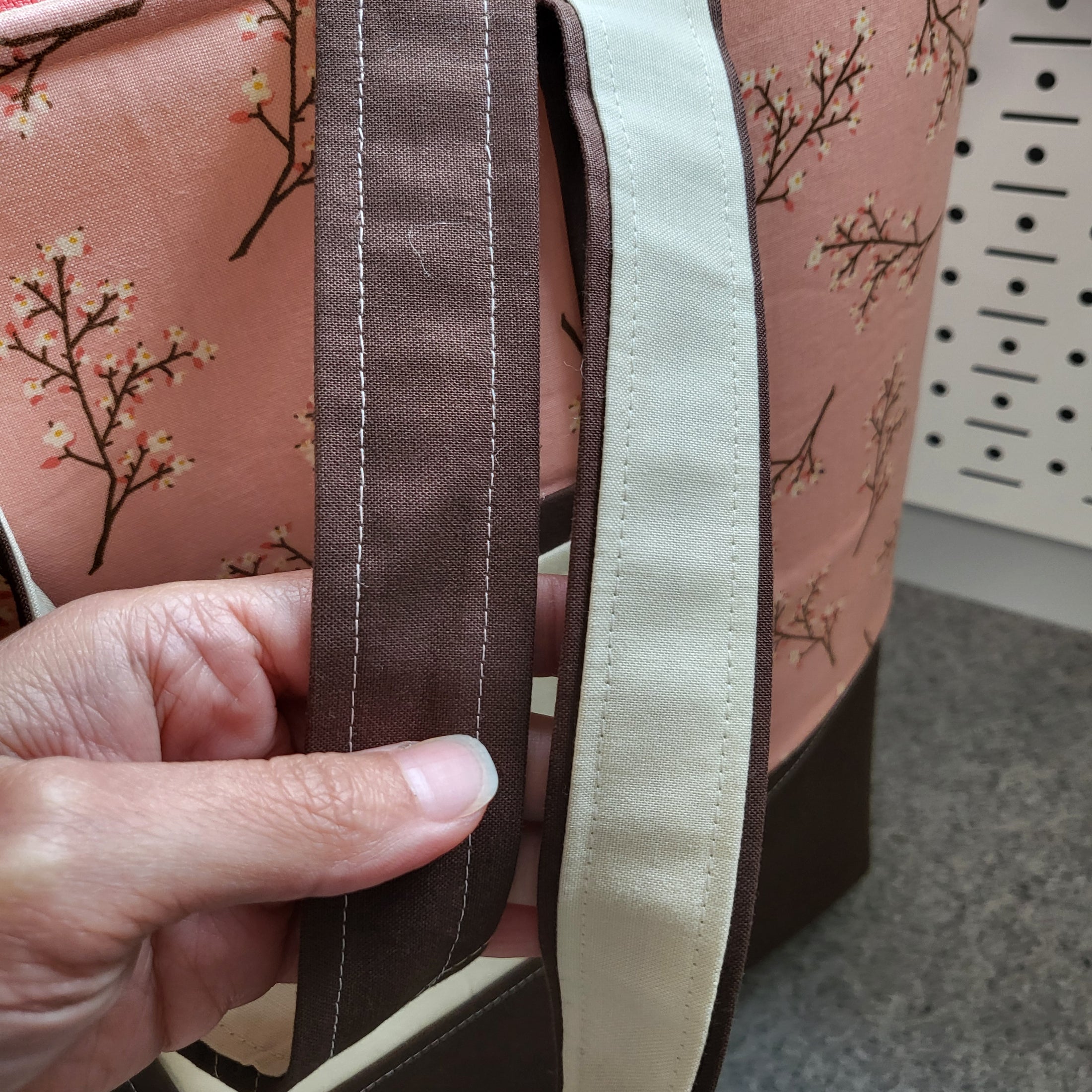 Brown and cream straps on the cherry blossom tote bag. 