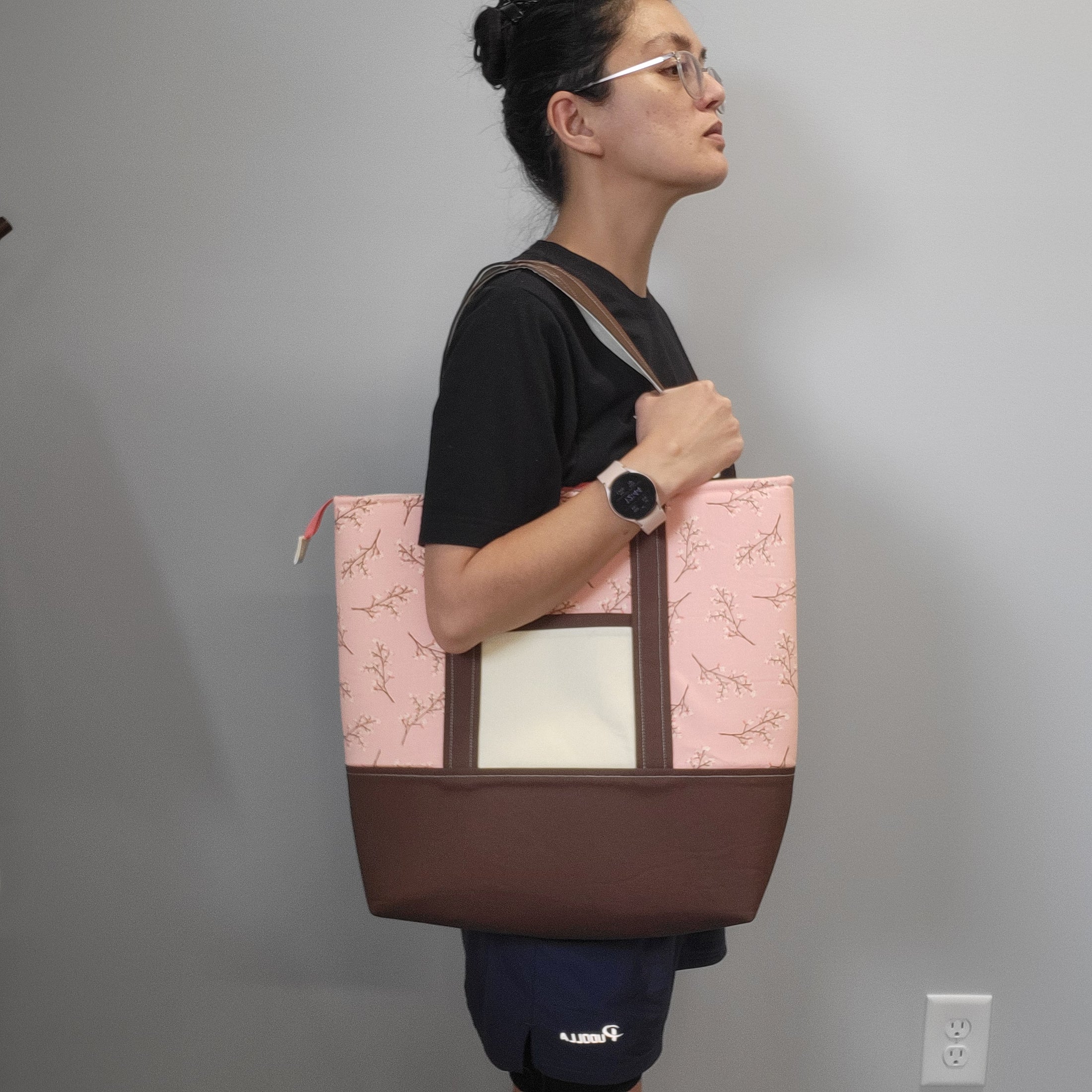 Lady wearing the cherry blossom tote bag on shoulder. 