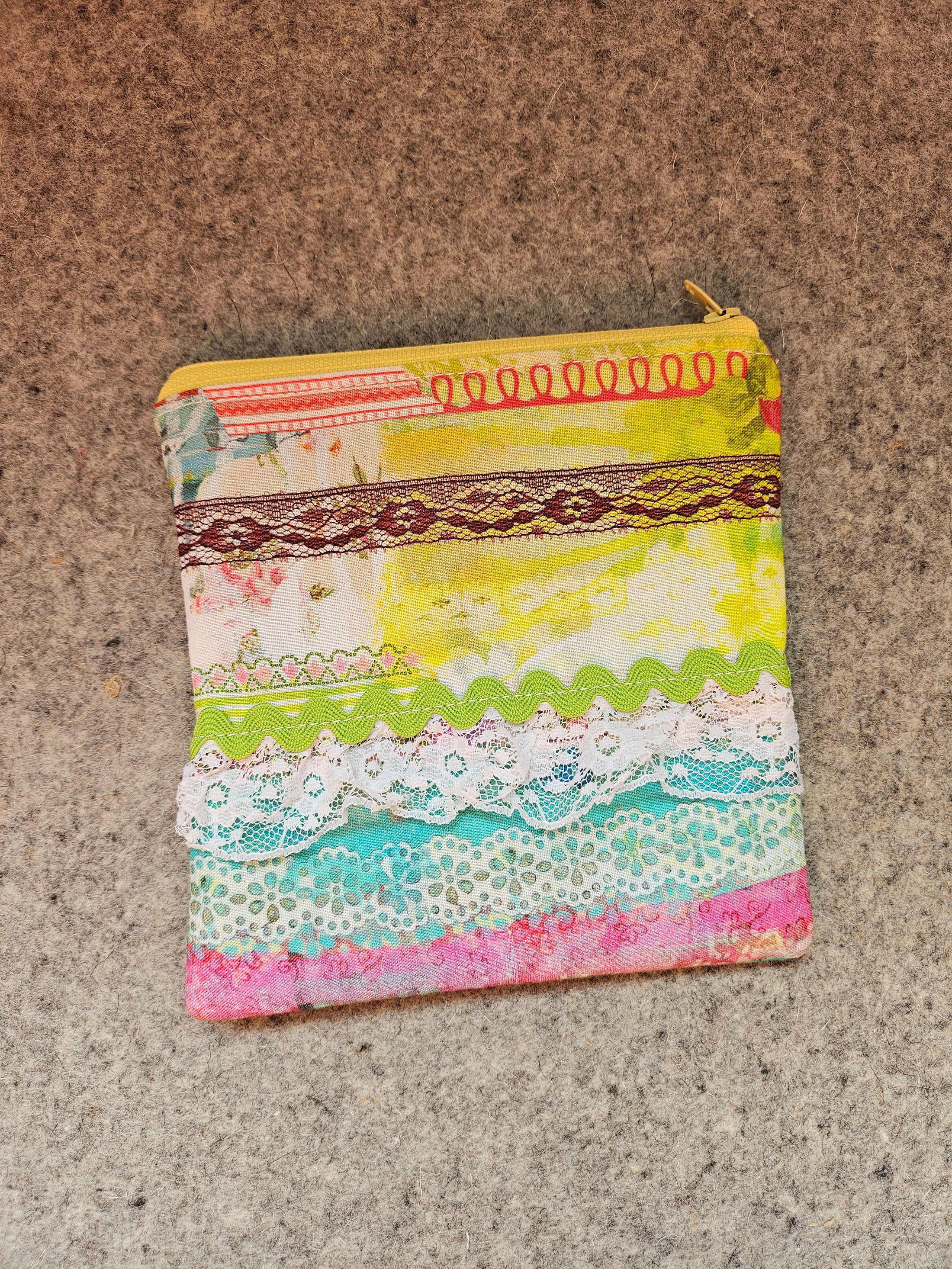 Watercolor lace zipper pouch with yellow zipper.