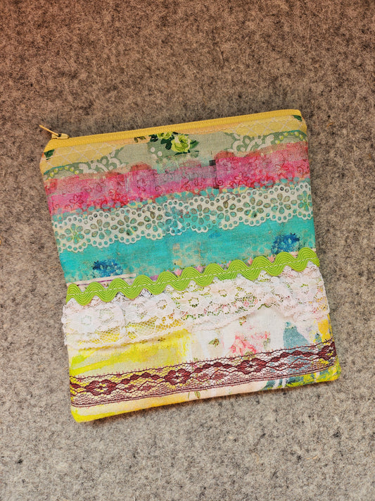 Watercolor lace zipper pouch embellished with lace and rick rack. 