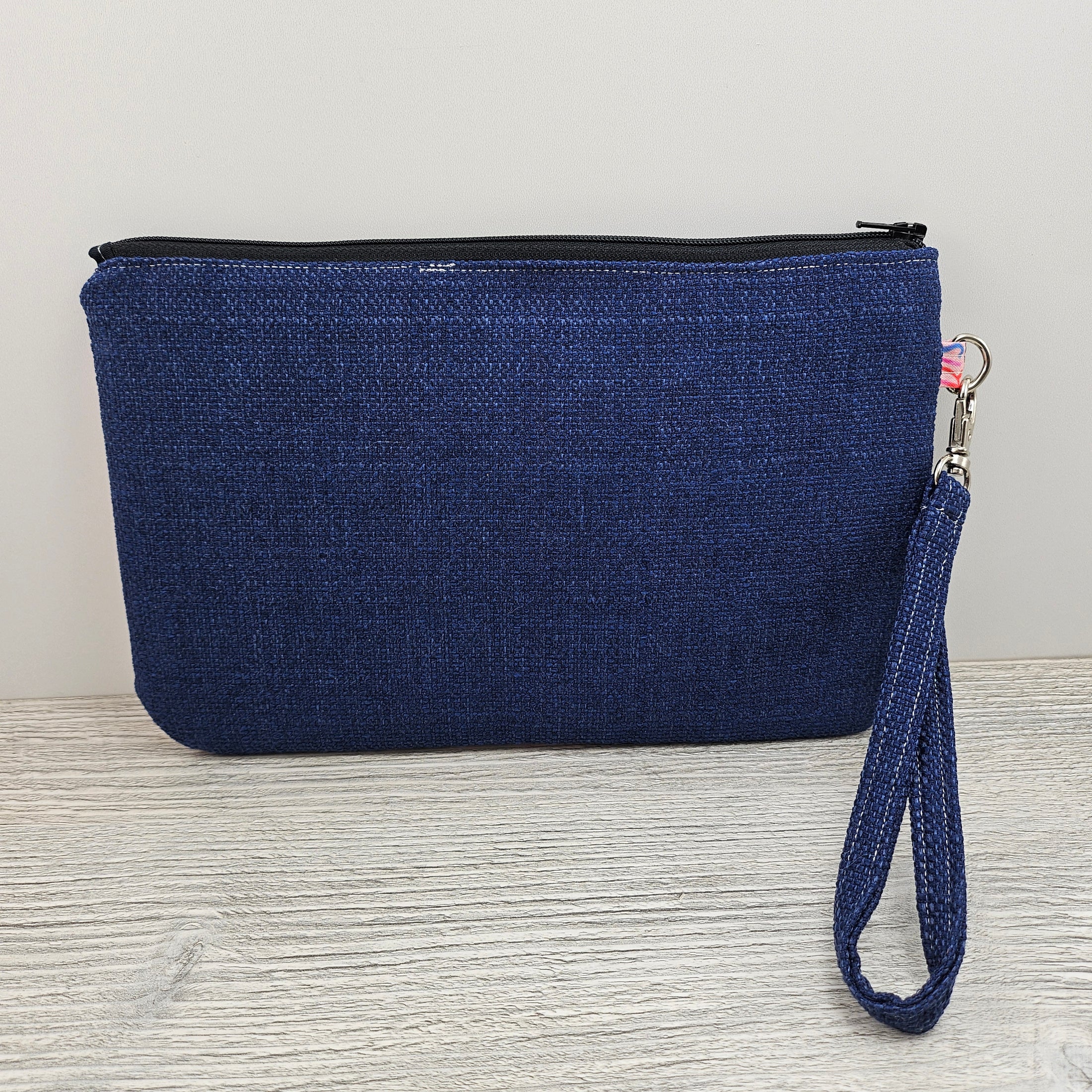 Blue back, black zipper and detachable wristlet strap.