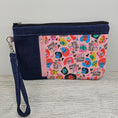 Load image into Gallery viewer, We rise by lifting others zippy clutch with black and pink zippers. 
