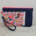 Load image into Gallery viewer, We rise by lifting others zippy clutch with 2 zipper compartments. 
