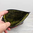 Load image into Gallery viewer, Labyrinth inspired wedge storage pouch with green interior.
