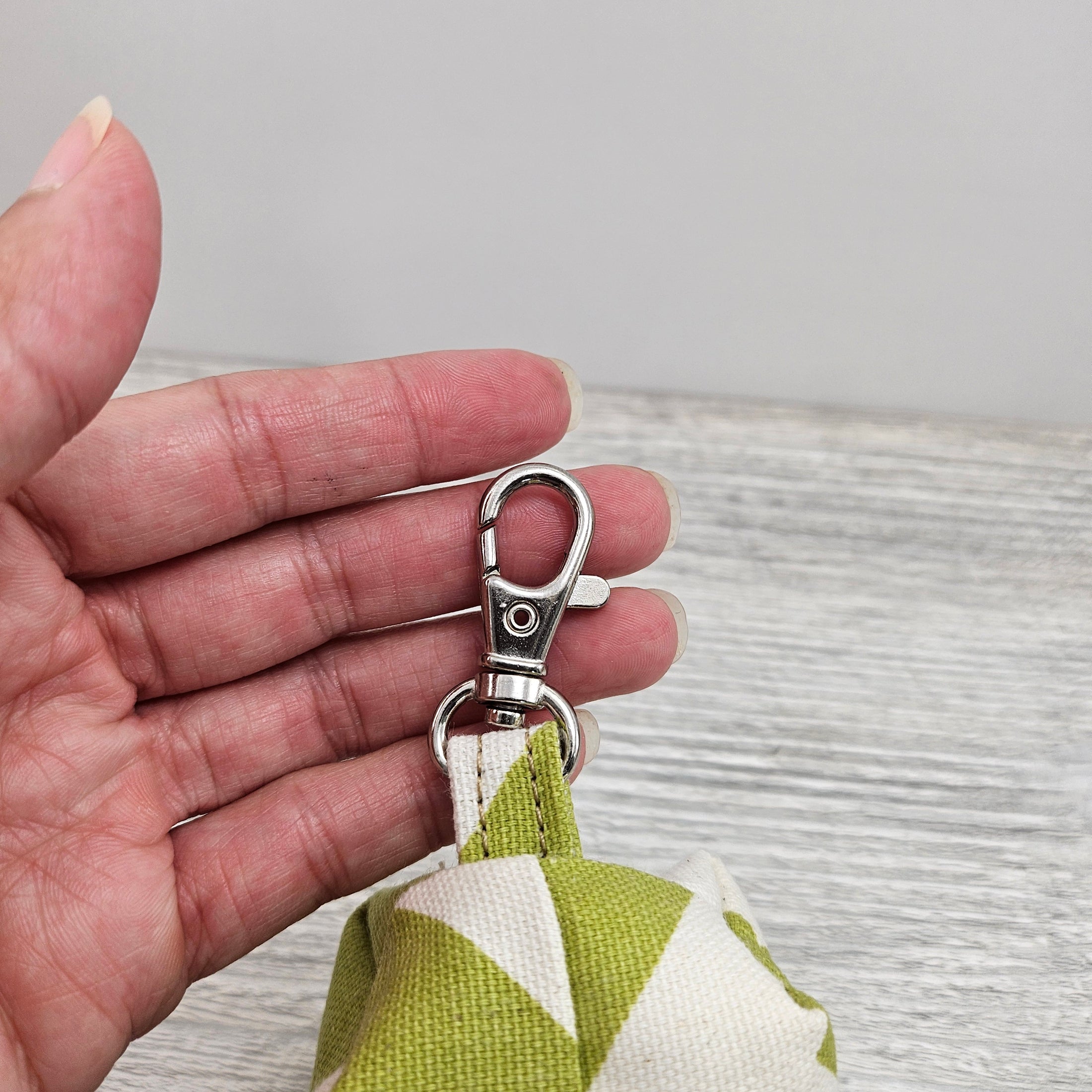 Green and cream tissue dispenser with swivel hook.