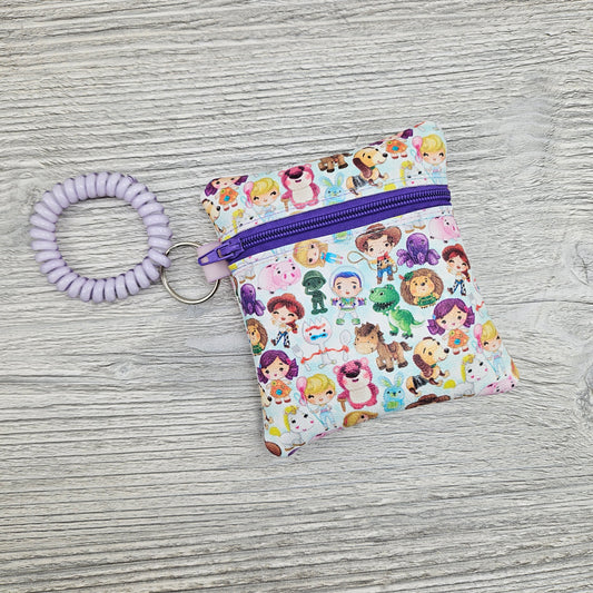 Mini vinyl zipper pouch featuring disney characters with a stretchy bracelet so you can wear it on your wrist. 