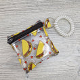 Load image into Gallery viewer, Mini clear vinyl with tacos zipper pouch with stretchy bracelet to wear on your wrist. 
