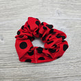 Load image into Gallery viewer, Red with black polka dots scrunchie. 
