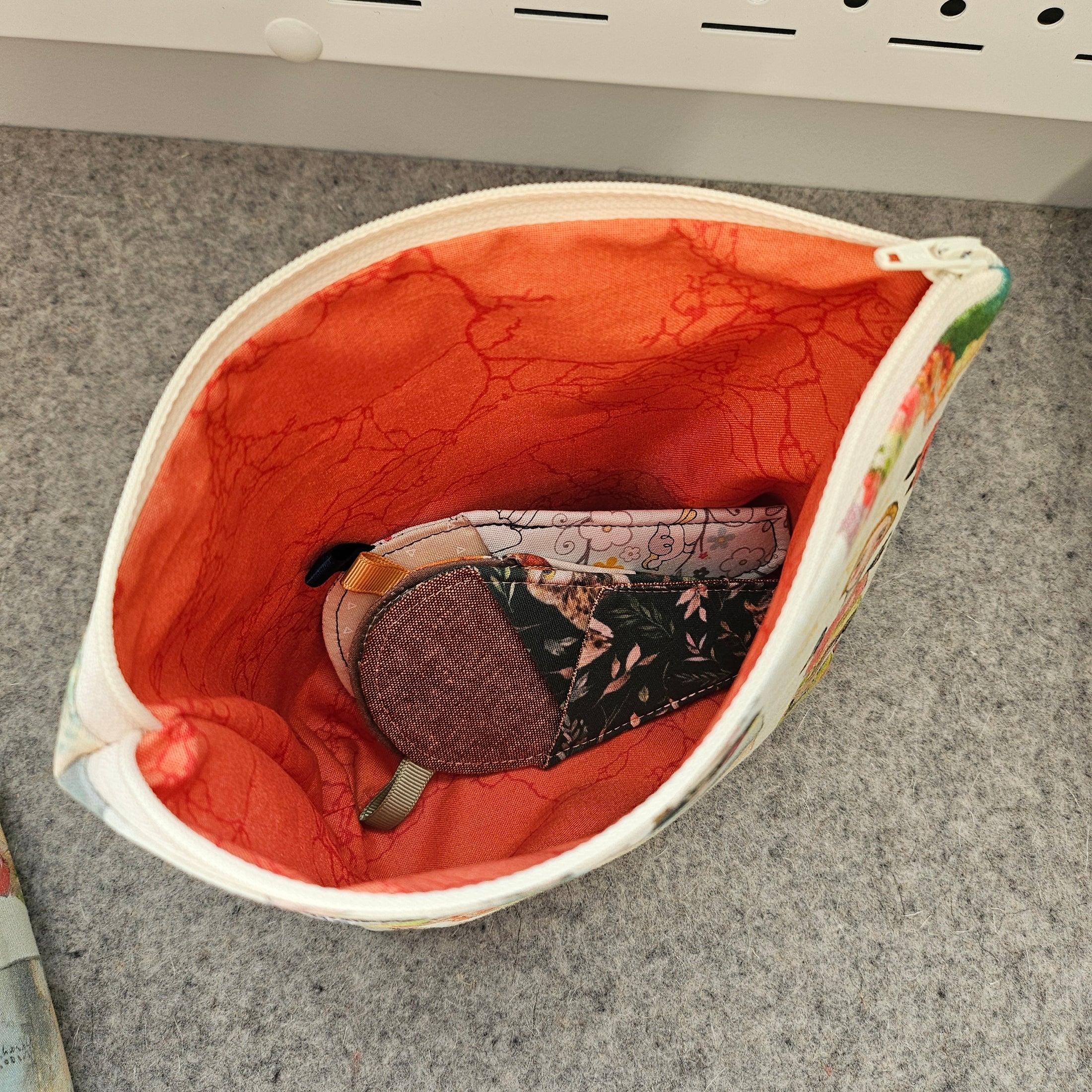 Orange marbled interior of a flat bottom zipper pouch.