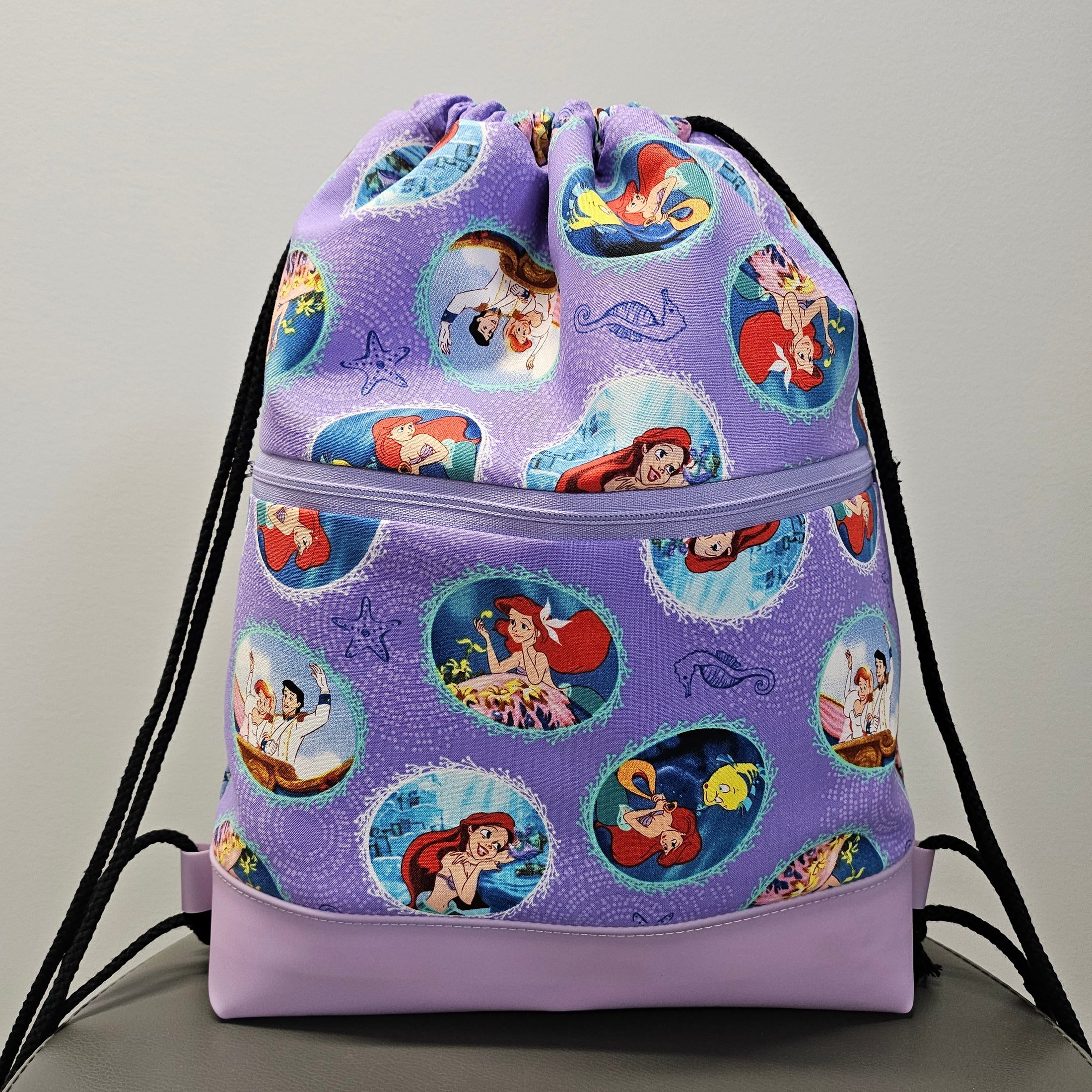 The Little Mermaid drawstring backpack with vinyl bottom.