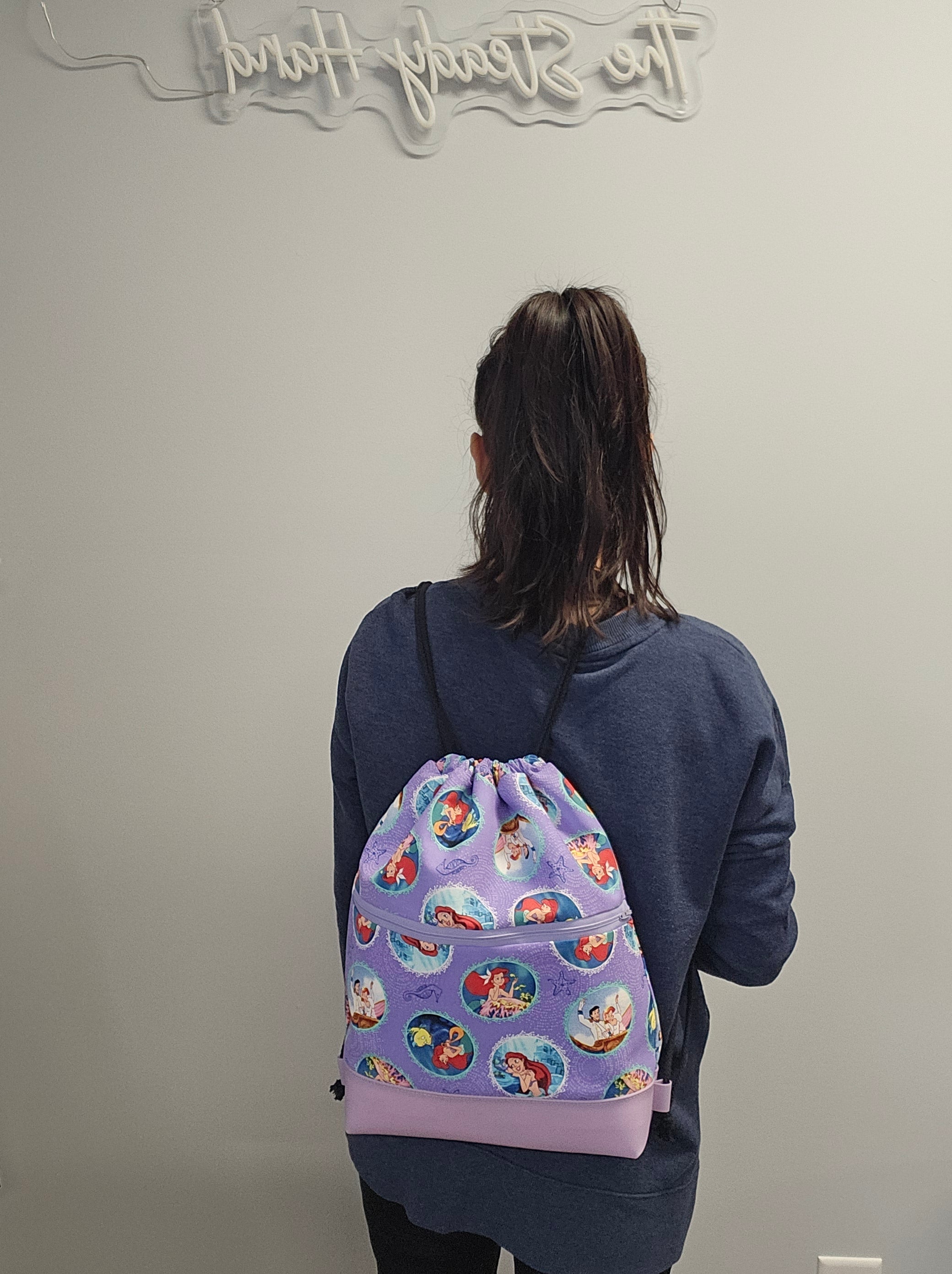 Wearing The Little Mermaid drawstring backpack.