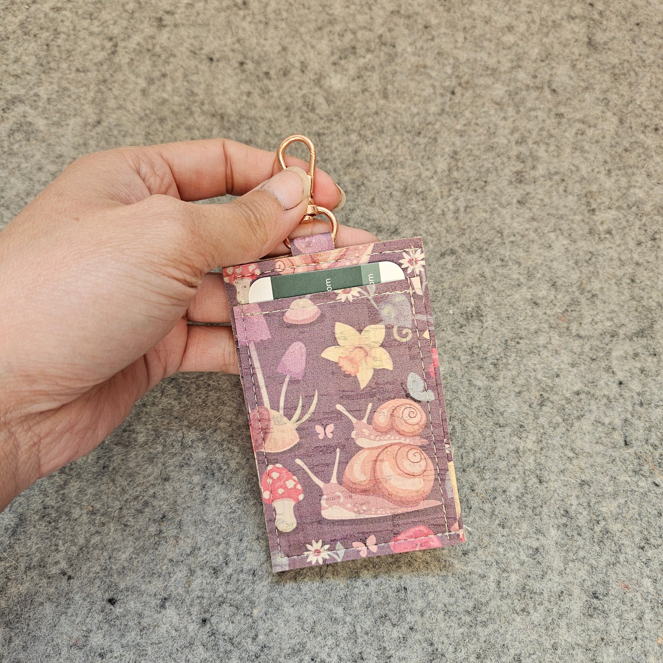Purple and pink cork wallet with snails and mushrooms.