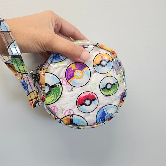 Colorful round pouch with pattern held by a hand against a plain background
