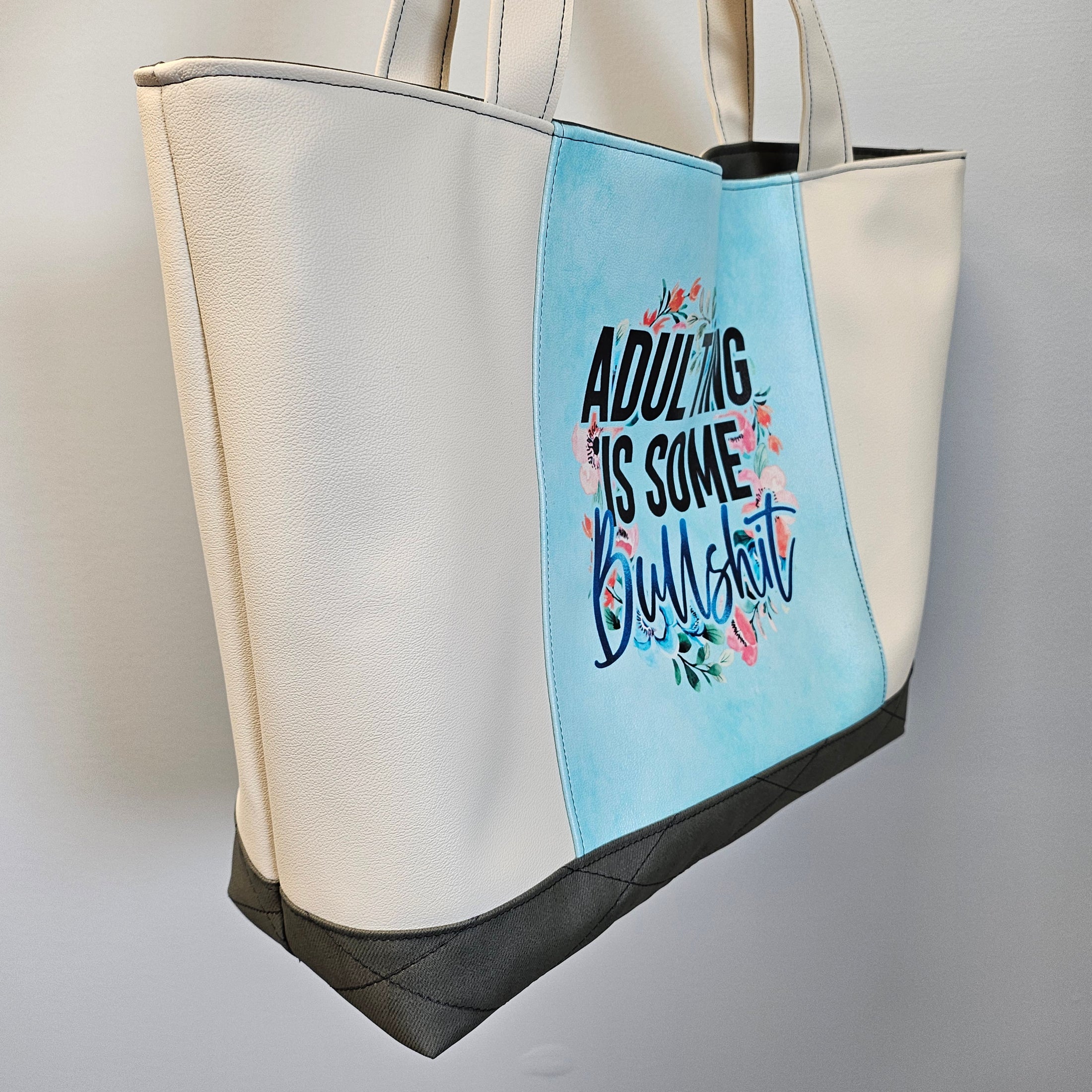 Tote bag with floral text design on a light blue background