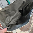 Load image into Gallery viewer, Gray vinyl canvas fabric interior of a tote bag with a hand holding it open.
