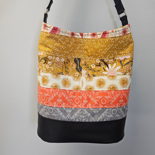 Patchwork-patterned bag with floral and abstract designs on a gray background