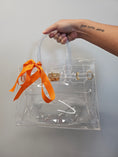 Load image into Gallery viewer, Clear firkin bag with orange ribbon.
