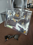 Load image into Gallery viewer, Clear purse sitting on a brown table.
