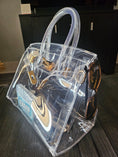 Load image into Gallery viewer, Clear birkie tote bag sitting on a dark brown table.
