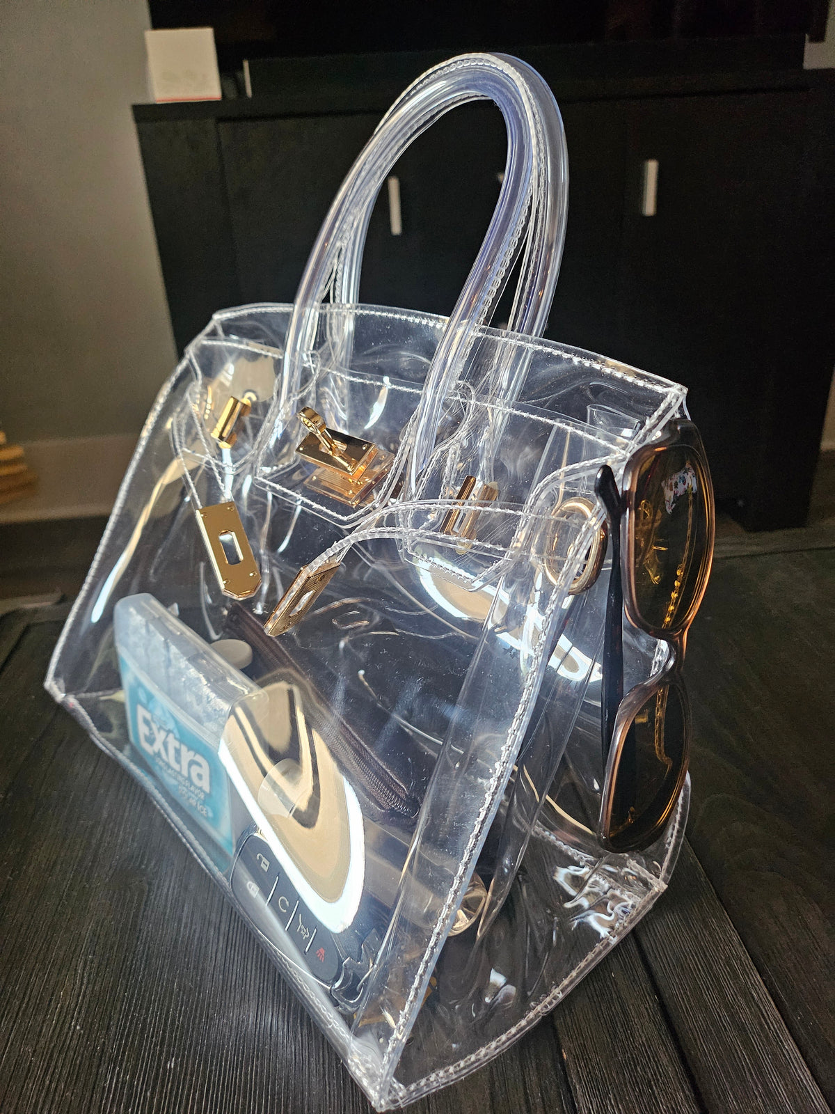 Clear birkie tote bag sitting on a dark brown table.