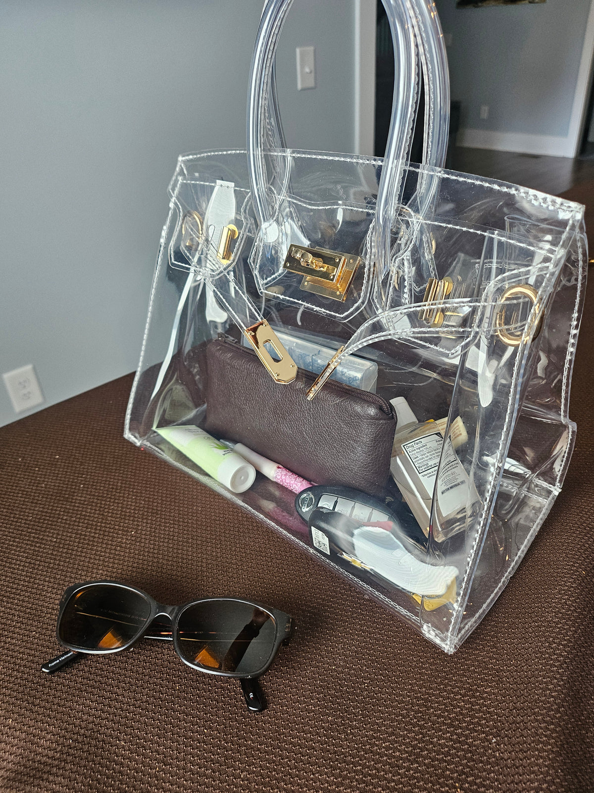 Clear crossbody purse sitting on a table.