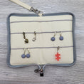 Load image into Gallery viewer, Deluxe stitch marker organizer open laid flat showing stitch markers. 

