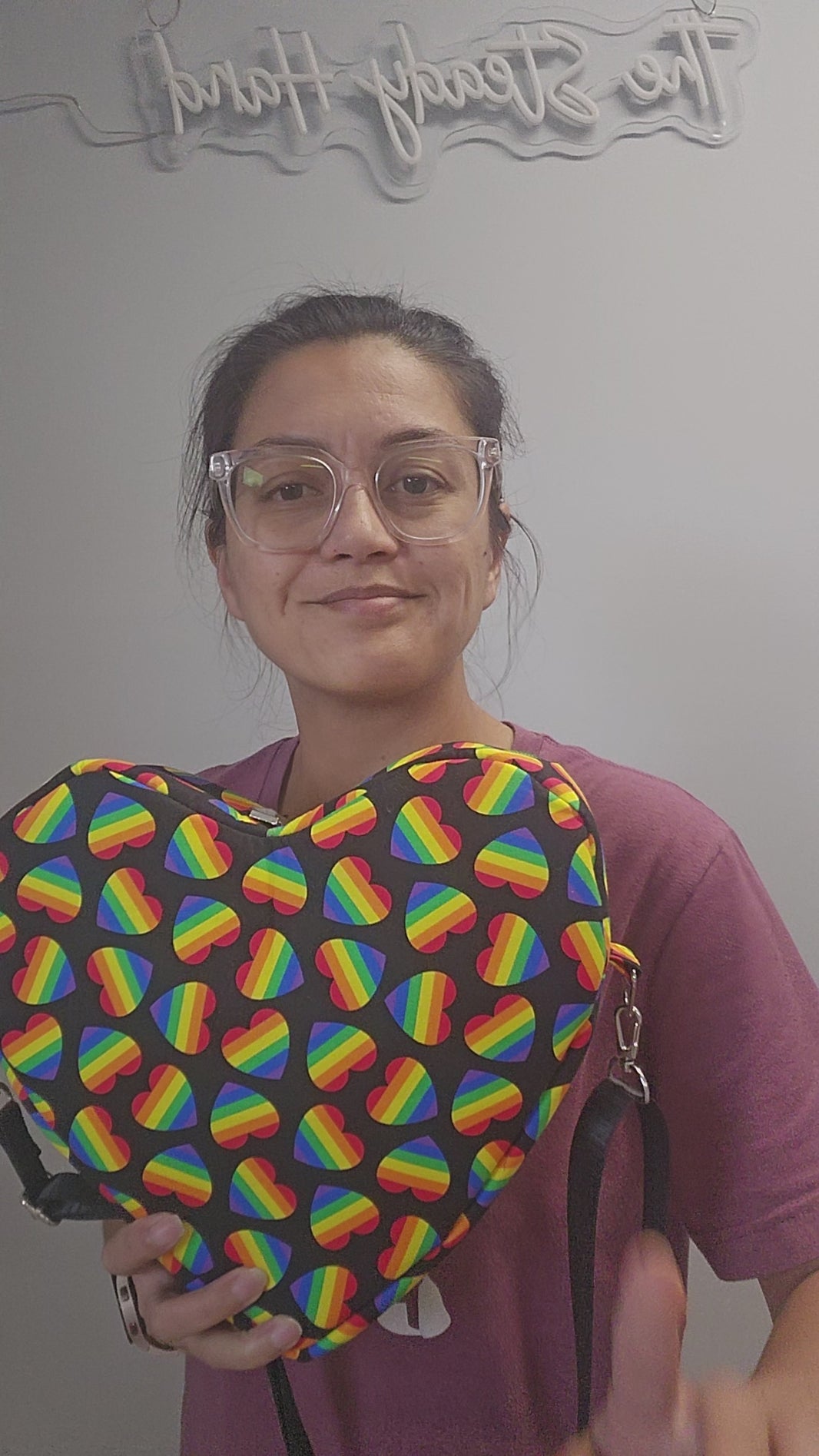 Video of black heart shaped bag with rainbow hearts.