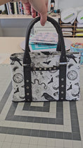 Load and play video in Gallery viewer, Video of black magic top handle trapeze purse.

