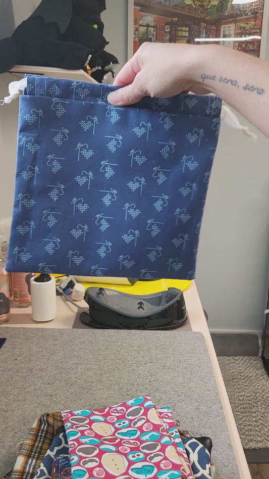 Video of dark blue drawstring bag with cross stitch design.