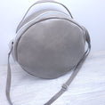 Load image into Gallery viewer, Taupe faux leather round crossbody purse.
