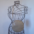 Load image into Gallery viewer, Vegan leather round crossbody purse hanging on metal dressform.
