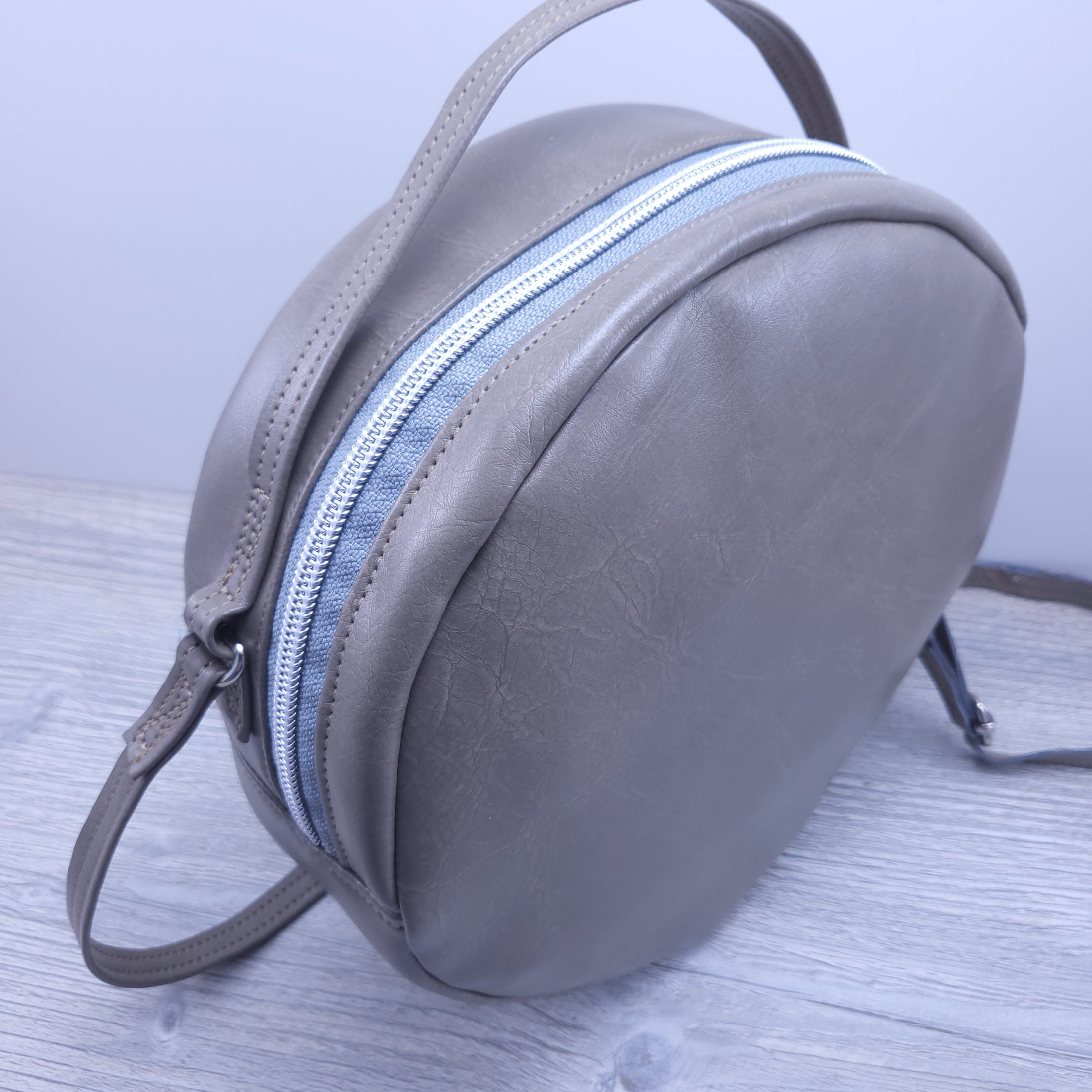 Top front of round vegan leather purse. 
